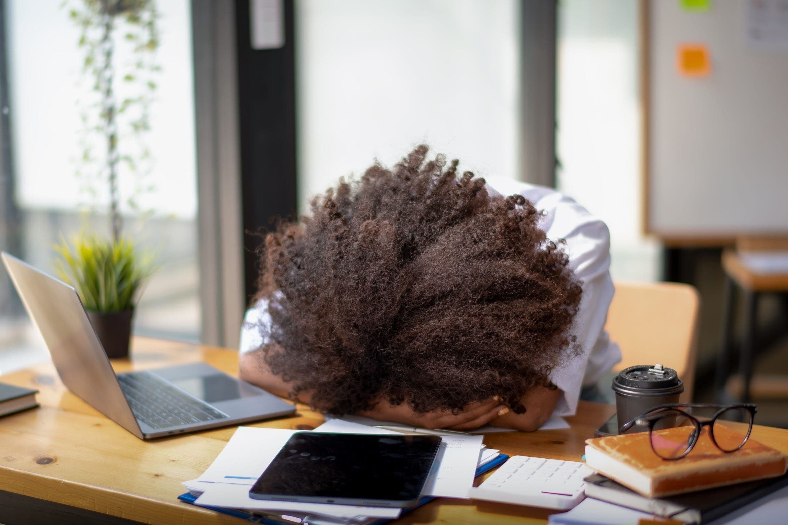 Person experiencing adhd burnout resting head on desk from mental exhaustion