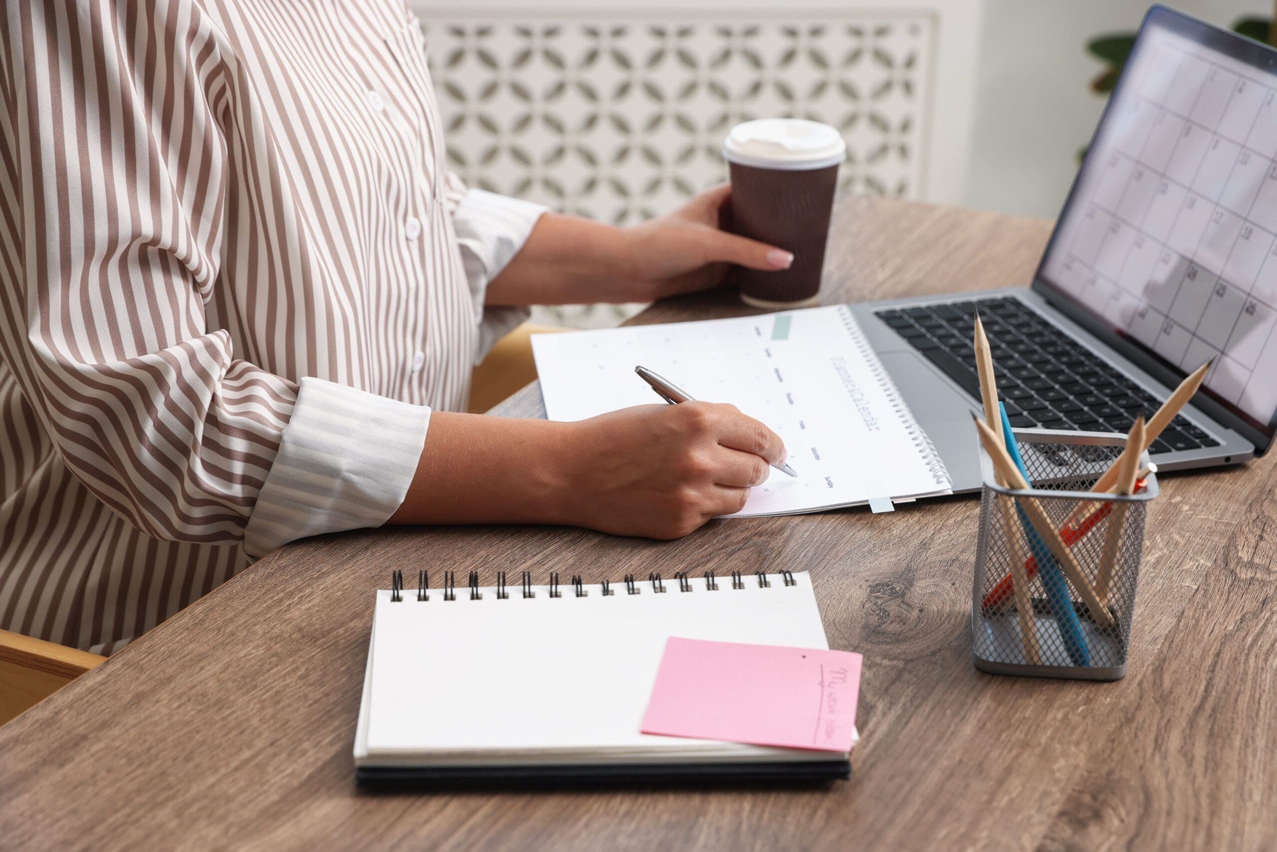 Person using planning worksheets and a laptop as part of cbt exercises for adhd to improve organization and focus.