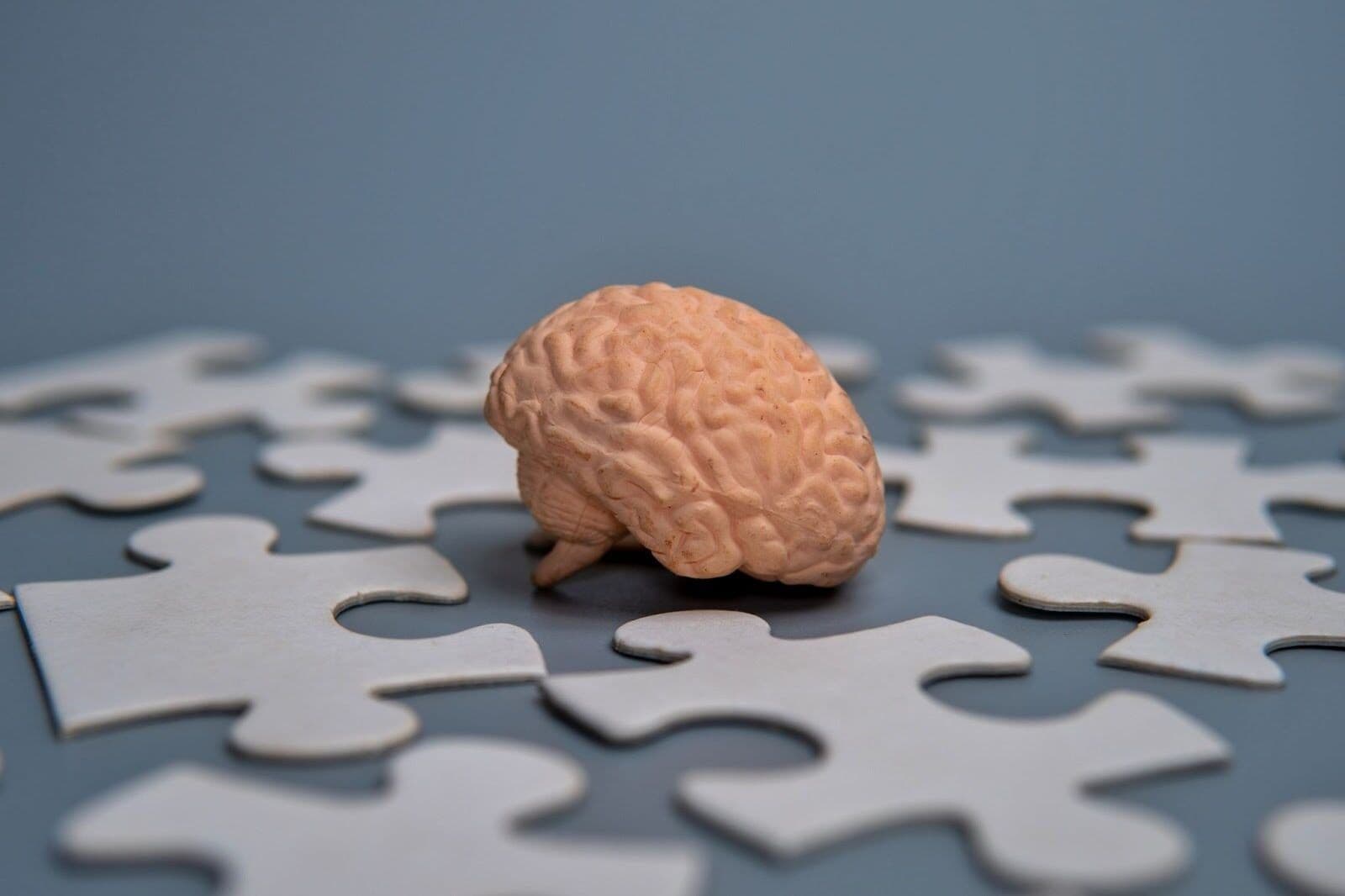 CPTSD and memory loss concept shown with brain model and missing puzzle pieces