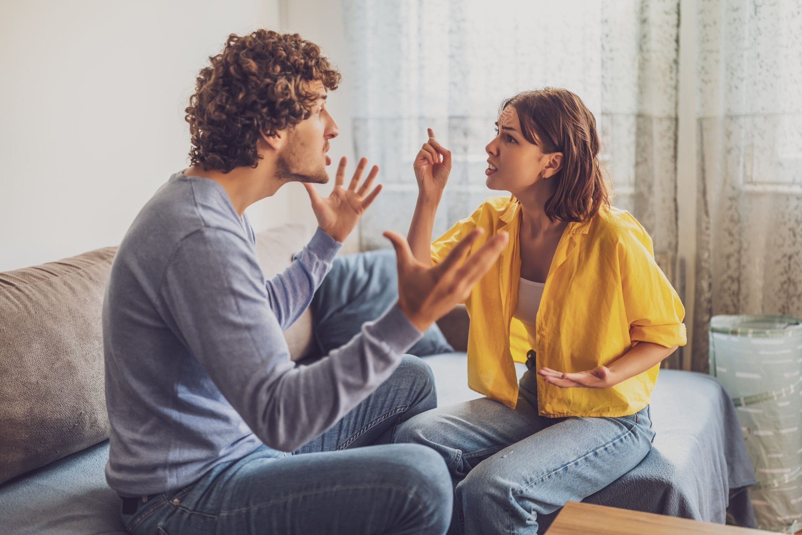 Couple arguing at home, showing relationship conflict caused by attachment issues.