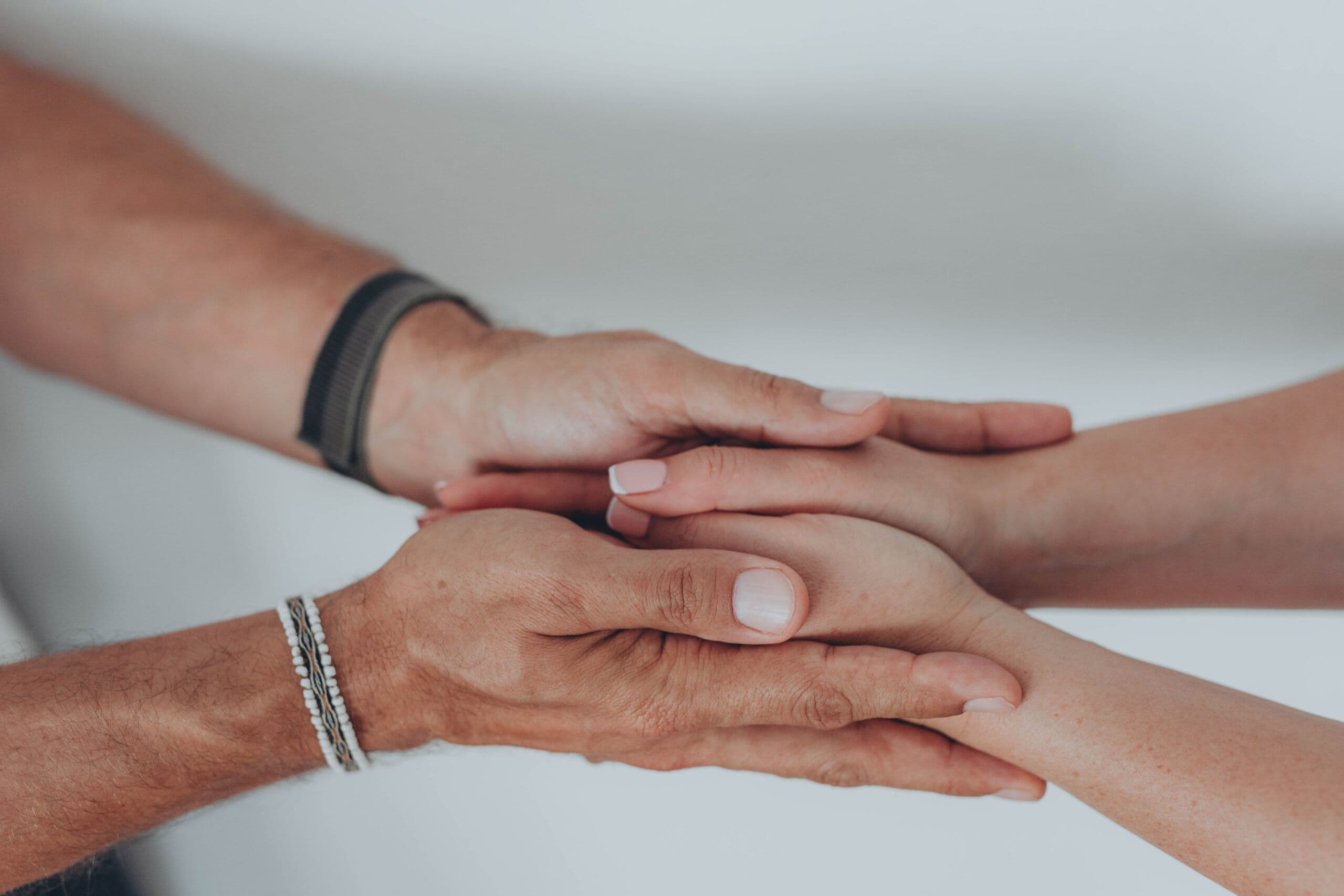 Hands gently holding in support, symbolizing comfort, empathy, and connection for international survivors of suicide loss.