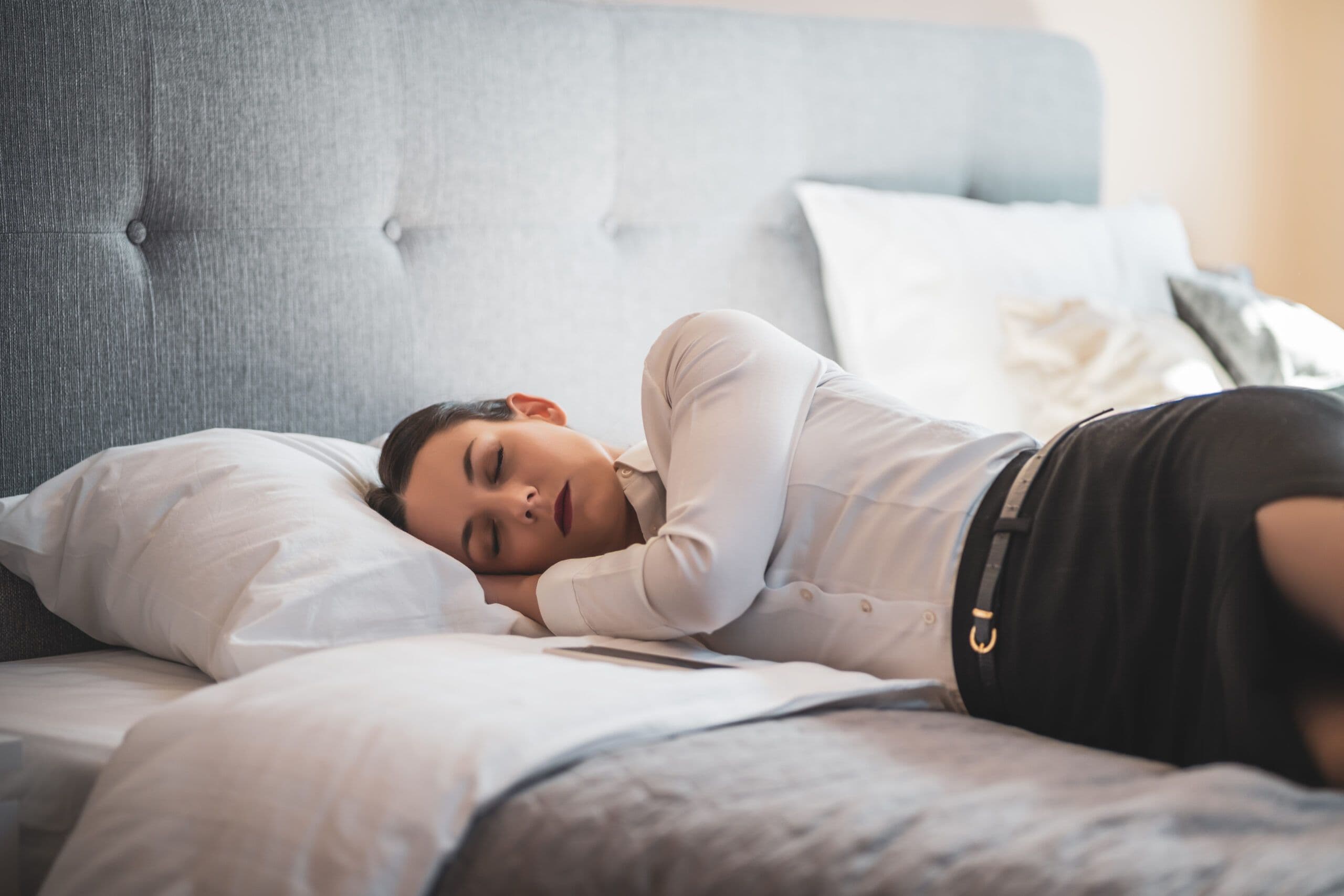 Napping and depression shown through a woman lying awake in bed during the day