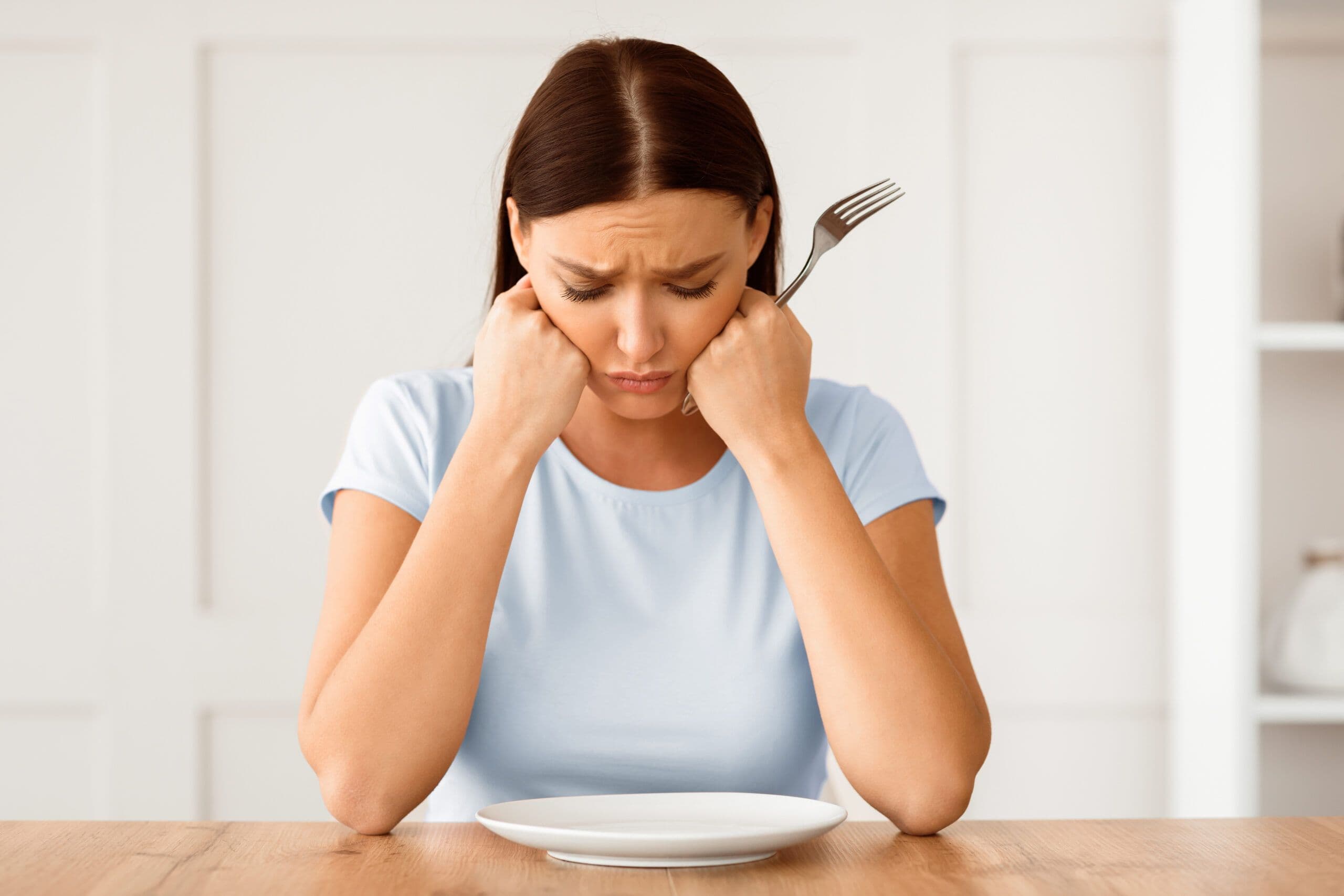 National Eating Disorders Awareness Week image showing a woman struggling with disordered eating during recovery