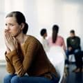 Woman in recovery group reflecting on pride vs. ego during addiction treatment.