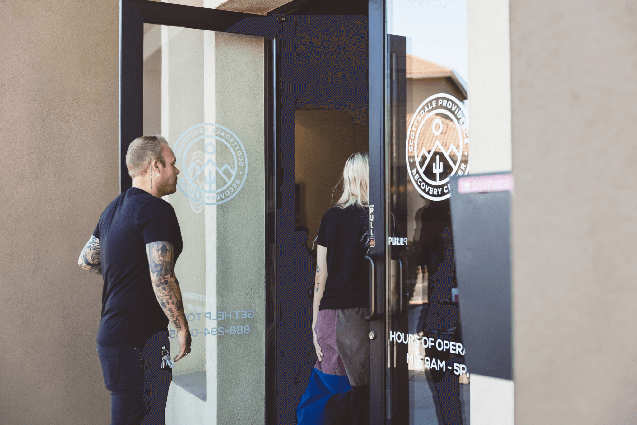 Two people entering Scottsdale Providence while considering residential vs. outpatient treatment.