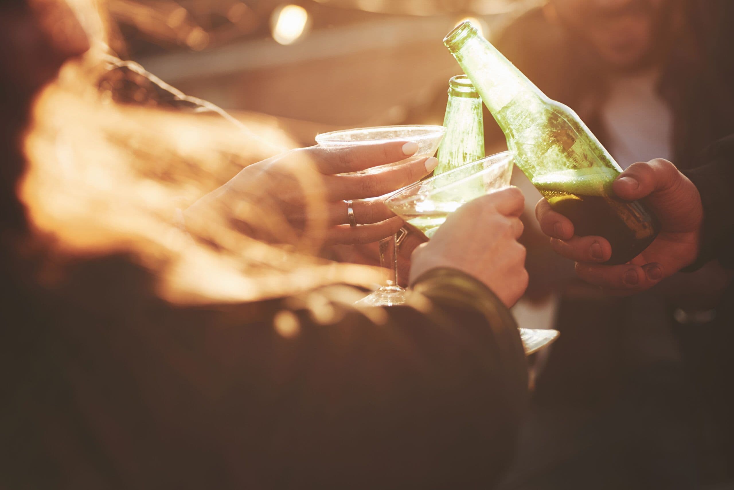 Teen alcohol use with friends drinking from bottles outdoors