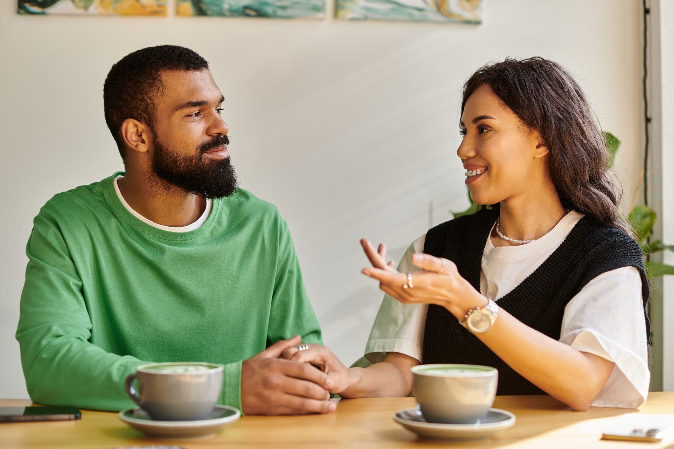 An African American couple enjoys a warm conversation over coffee in a charming cafe.